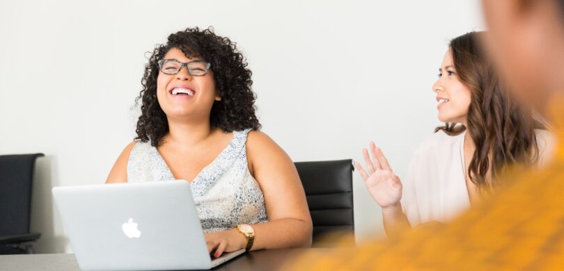Woman sitting at computer laughing