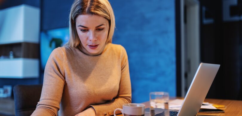 A woman sits at a computer.