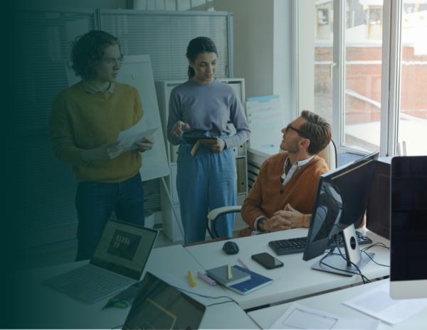 A team of professionals in a busy office setting. There is a teal blue gradient overlay on the image.
